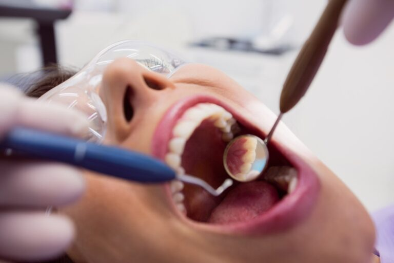 Dentist examining female patient's teeth